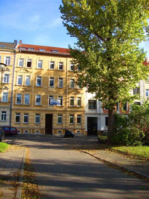 Viergeschossiges Wohnhaus mit gelber Fassade, Ziegeldach und regelmäßigen Fensterreihen, Dantestraße in Leipzig-Möckern