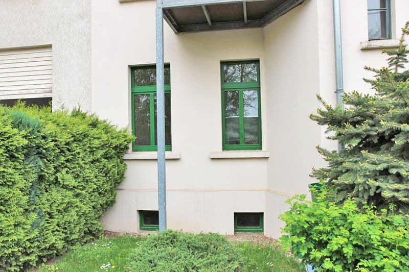 Helles Wohnhaus mit Putzfassade, grüne Fenster und Metalldachüberstand, Endersstraße in Leipzig-Lindenau