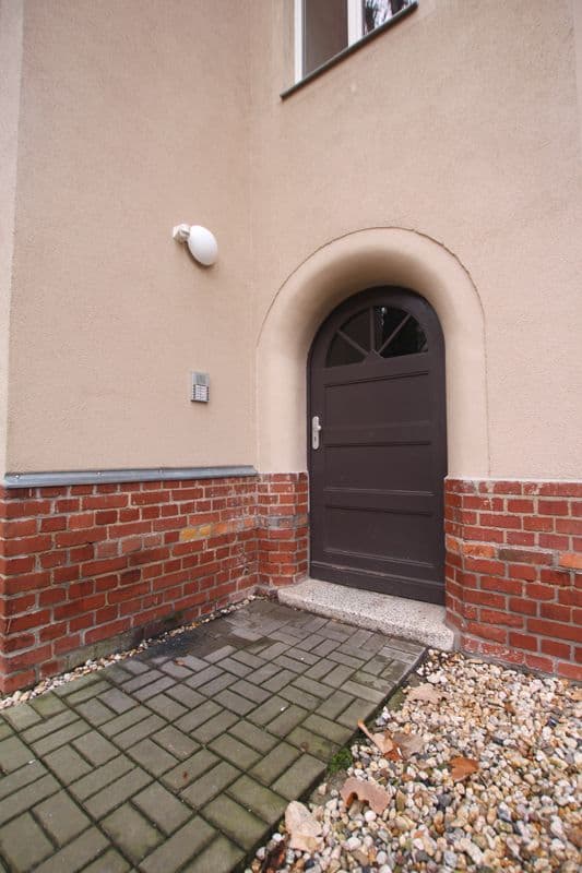 Hauseingang mit brauner Tür unter Rundbogen, Backsteinzockel, Putzfassade, Eythraer Straße in Leipzig