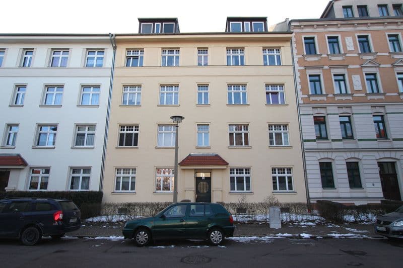 Fünfgeschossiges Wohnhaus mit beige verputzter Fassade und Mansardendach, Eythraer Straße in Leipzig-Kleinzschocher