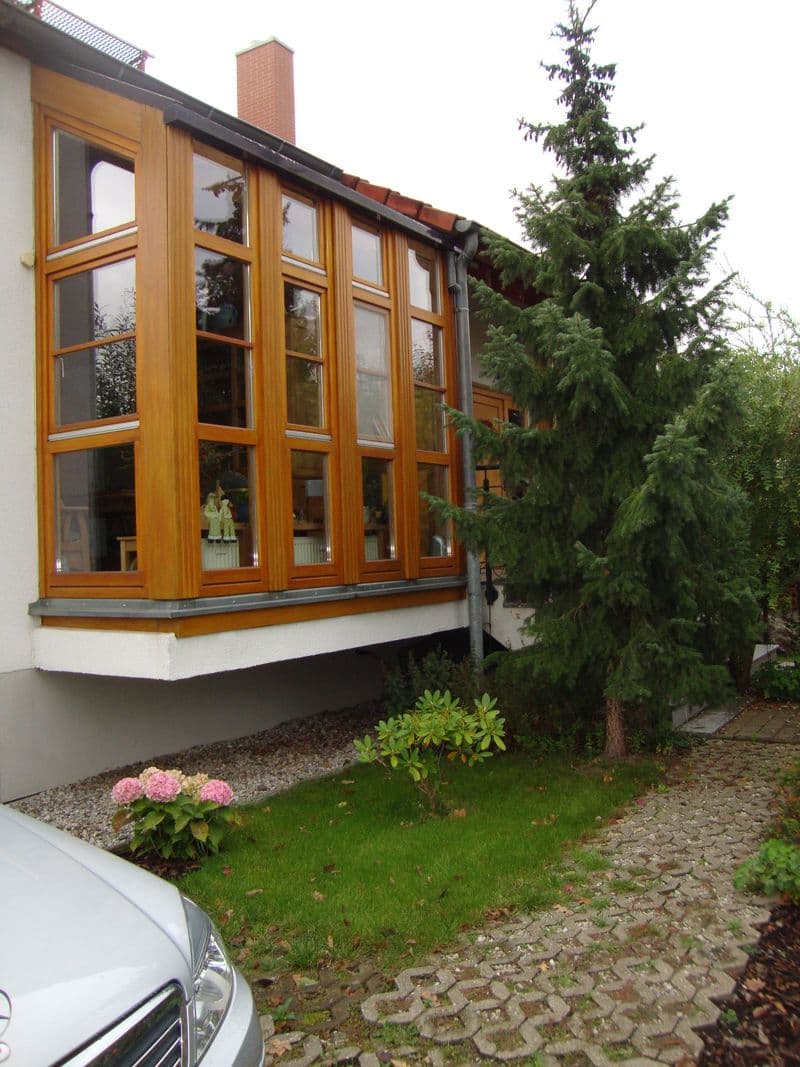 Einfamilienhaus mit weißer Fassade, großflächiger Holzfensterfront, Ziegelschornstein, Feldstraße in Leipzig-Holzhausen