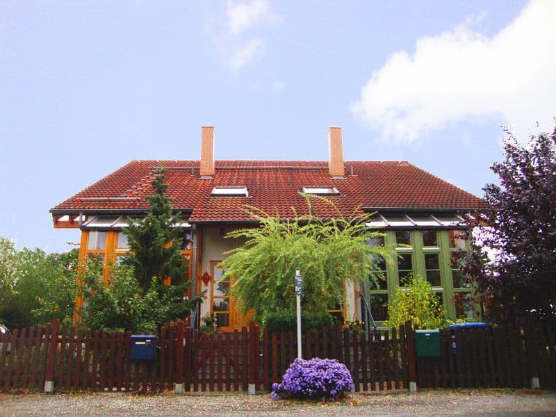 Zweifamilienhaus mit Ziegeldach, roten Klinkersteinen, grünen Fensterrahmen, zwei Kaminen, Feldstraße in Leipzig-Holzhausen