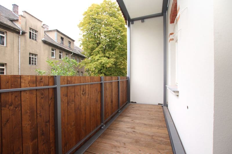 Schmaler Balkon mit Holzdielenboden, weißer Wand rechts, Holzzaun links, Georg-Schumann-Straße in Leipzig-Gohlis-Süd