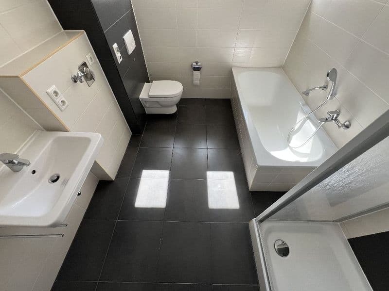 Badezimmer mit schwarzem Fliesenboden, weißer Badewanne, Toilette, Hauffweg in Leipzig