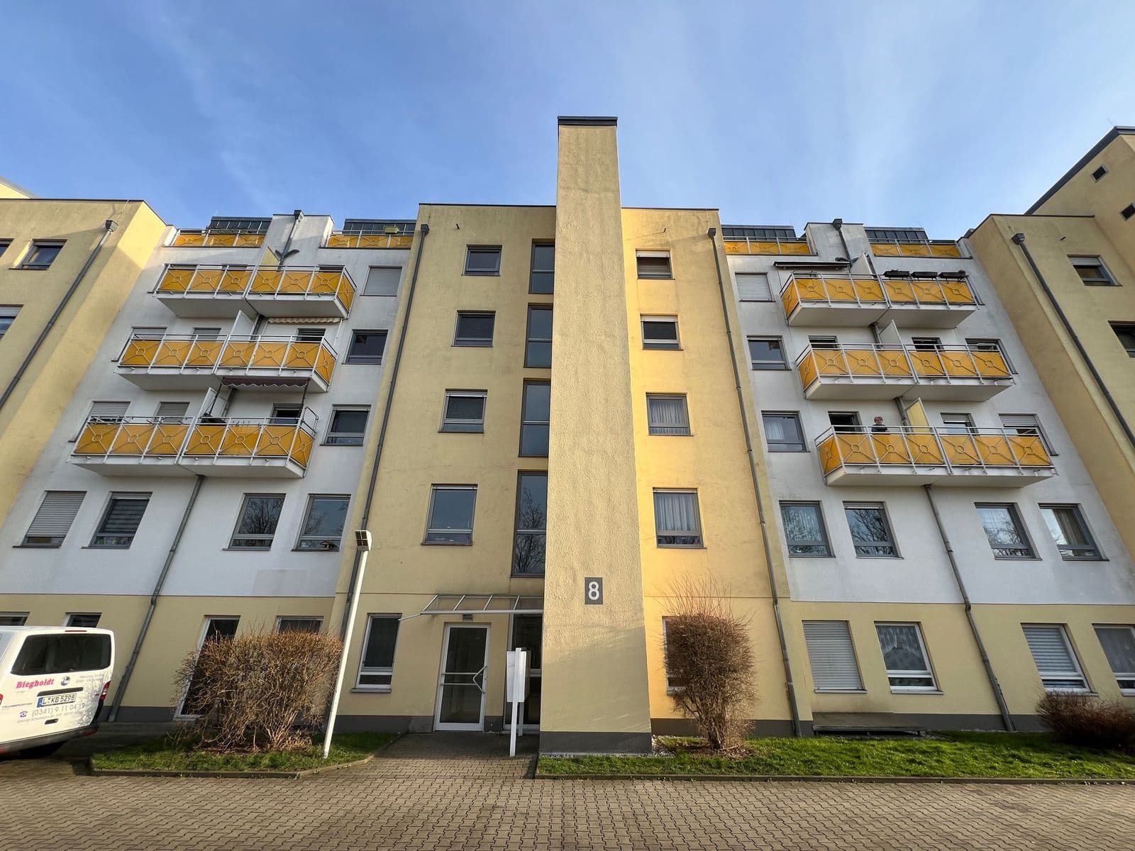 Mehrfamilienhaus mit fünf Geschossen, Fassade in Creme und Weiß, gelbe Balkone, Horst-Heilmann-Straße in Leipzig-Möckern