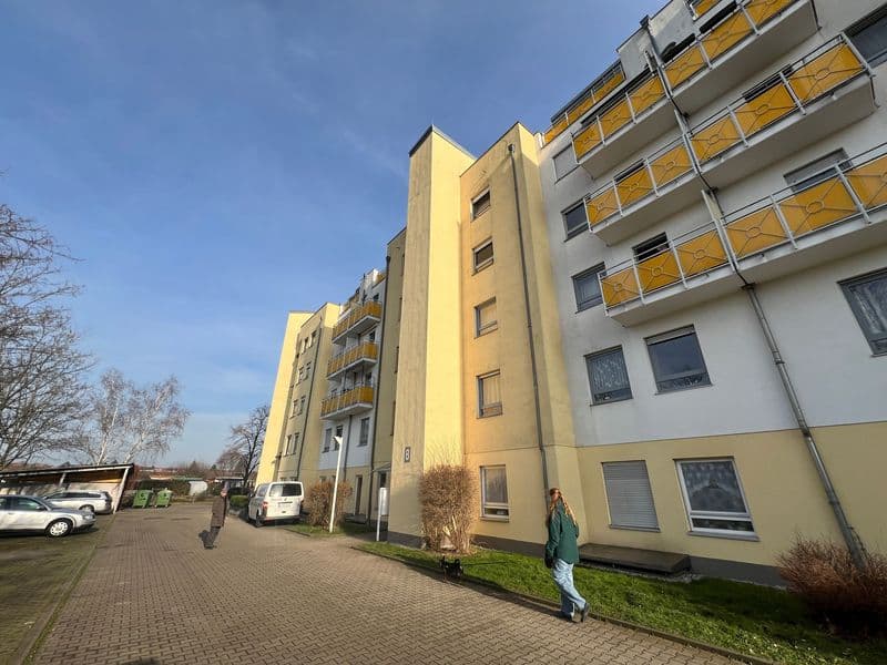 Mehrgeschossiges Wohngebäude mit gelber Fassade und Balkonen, Horst-Heilmann-Straße in Leipzig-Möckern