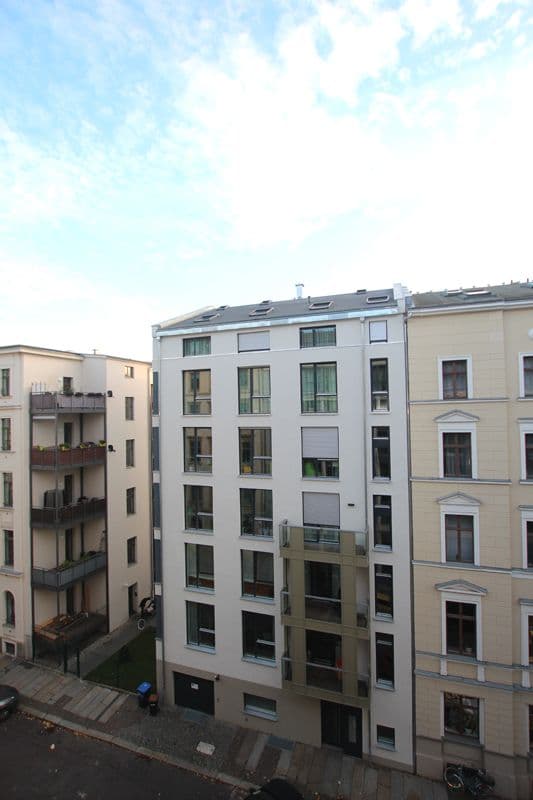 Mehrgeschossiges Wohngebäude mit weißer Putzfassade, großflächigen Fenstern und flachem Dach, Humboldtstraße in Leipzig