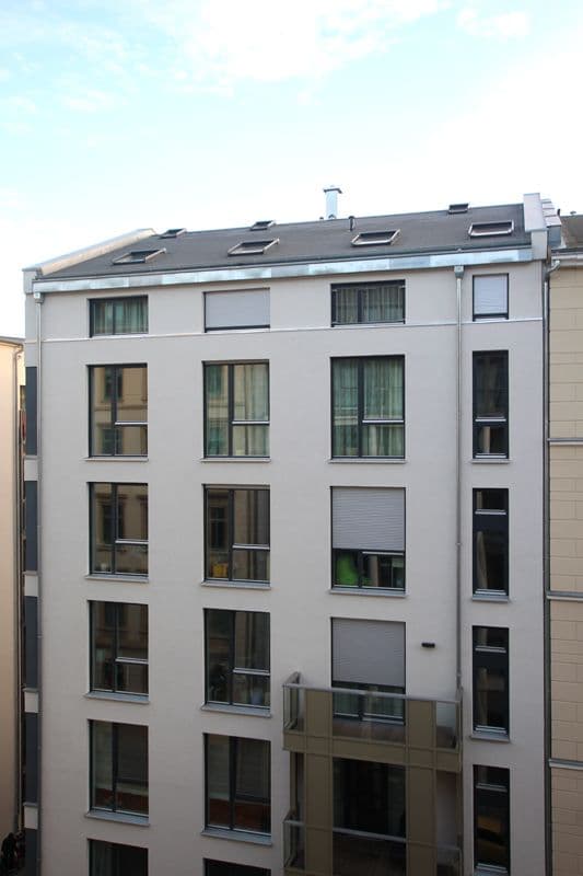 Fünfgeschossiges Wohnhaus mit weißer Fassade, Flachdach mit Dachfenstern und Gauben, Humboldtstraße in Leipzig