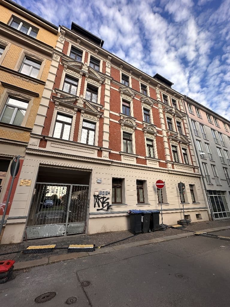 Fünfgeschossiges Gründerzeitgebäude mit Klinkerfassade in Rot und Creme, Stuckverzierungen, Laden im Erdgeschoss