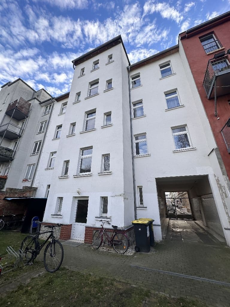 Fünfgeschossiges Wohnhaus mit weißer Putzfassade, regelmäßiger Fensterreihe und Flachdach, Karl-Ferlemann-Straße in Leipzig