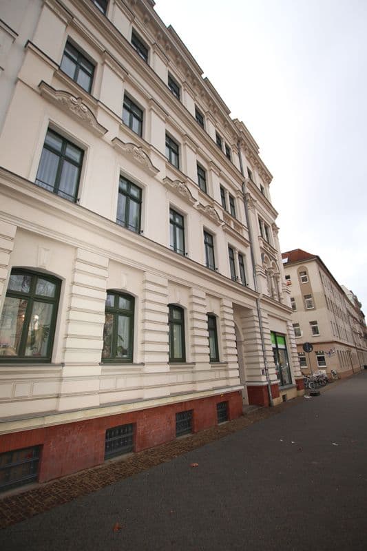 Gründerzeithaus mit fünf Geschossen, weiße Stuckfassade, rotes Sockelgeschoss, Karl-Heine-Straße in Leipzig-Plagwitz