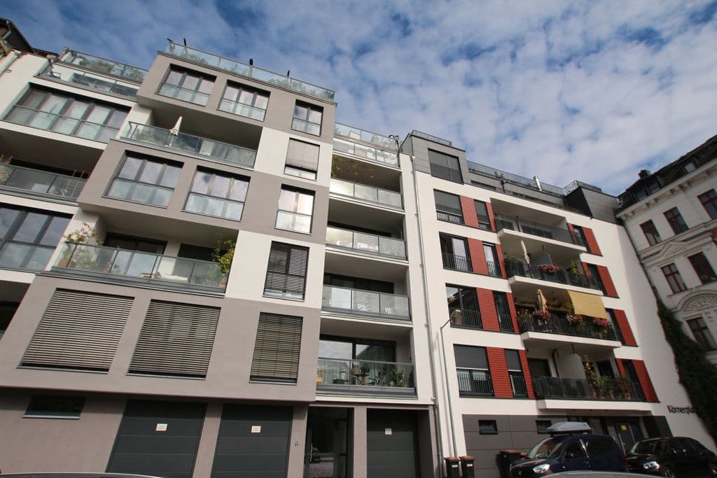 Fünfgeschossiges Wohngebäude mit Putzfassade, Balkone und Loggien, rote Akzente, Flachdach, Körnerplatz in Leipzig