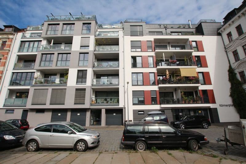 Mehrgeschossige Wohnhäuser mit weißer und roter Fassade, Balkone, Erdgeschoss-Einzelhandelsflächen, Körnerplatz in Leipzig