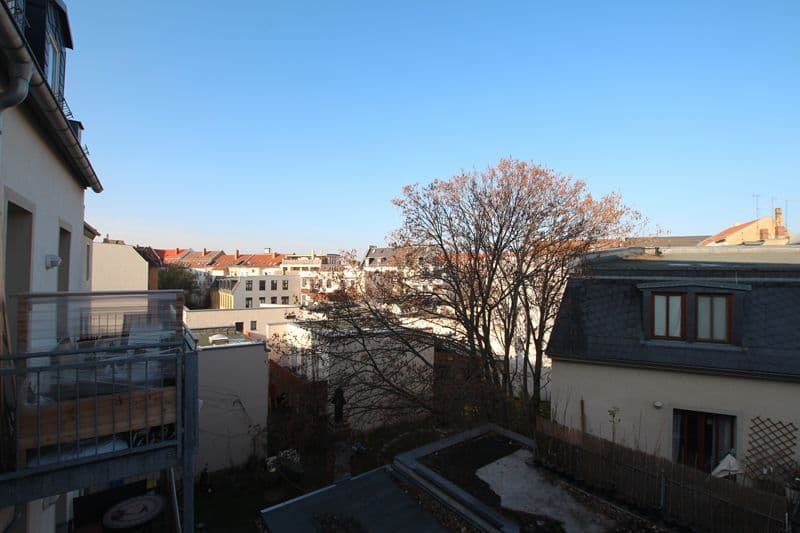Blick über Innenhof mit Laubbaum auf mehrstöckige Wohnhäuser mit Ziegeldächern, Lauchstädter Straße in Leipzig-Plagwitz
