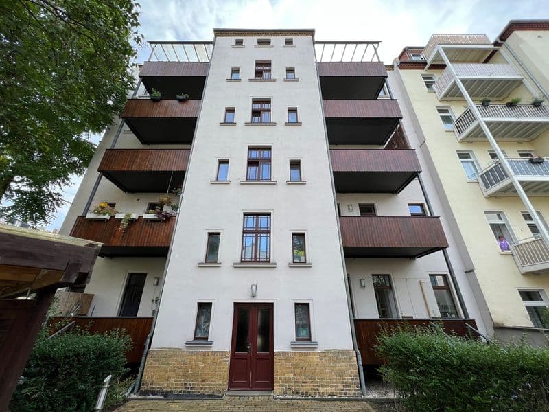 Sechsgeschossiger Wohnblock mit weißer Fassade, rostbrauen Balkonen und Metalldächern, Mechlerstraße in Leipzig