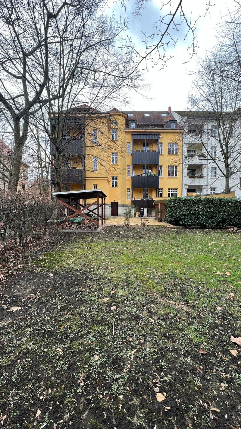 Viergeschossiges Wohnhaus mit gelber Fassade, schwarze Balkone, Mansarddach, Naunhofer Str. in Leipzig-Stötteritz