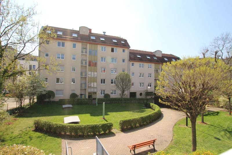 Vierstöckiges Wohnhaus mit beiger Fassade und Mansardendach, Niederkirchnerstraße in Leipzig