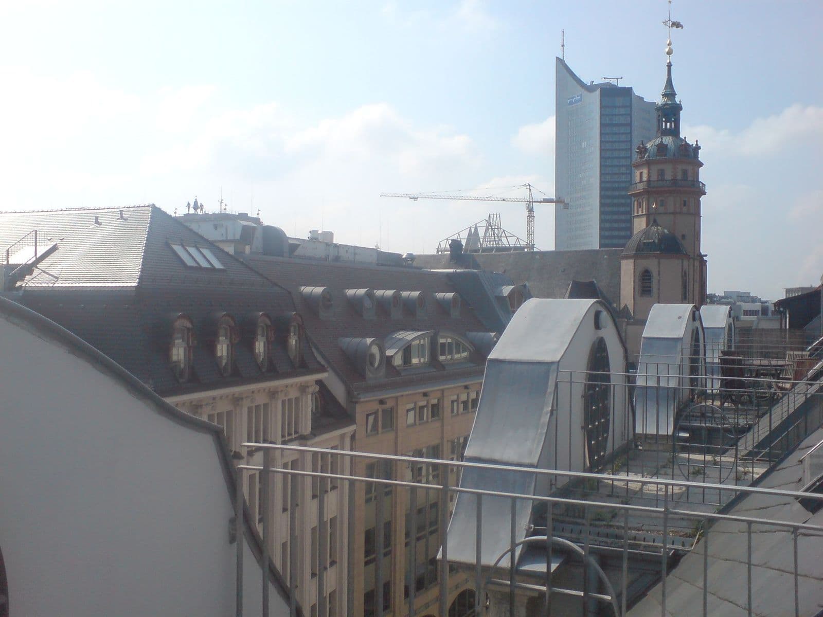 Blick über Dächer und Innenhof auf Gründerzeitgebäude, Kirchturm und modernes Hochhaus, Nikolaistraße in Leipzig-Zentrum