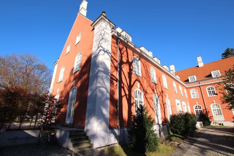 Rote Ziegelfassade mit weißen Fensterreihen, Satteldach mit Schornsteinen, Paul-Michael-Straße in Leipzig-Leutzsch