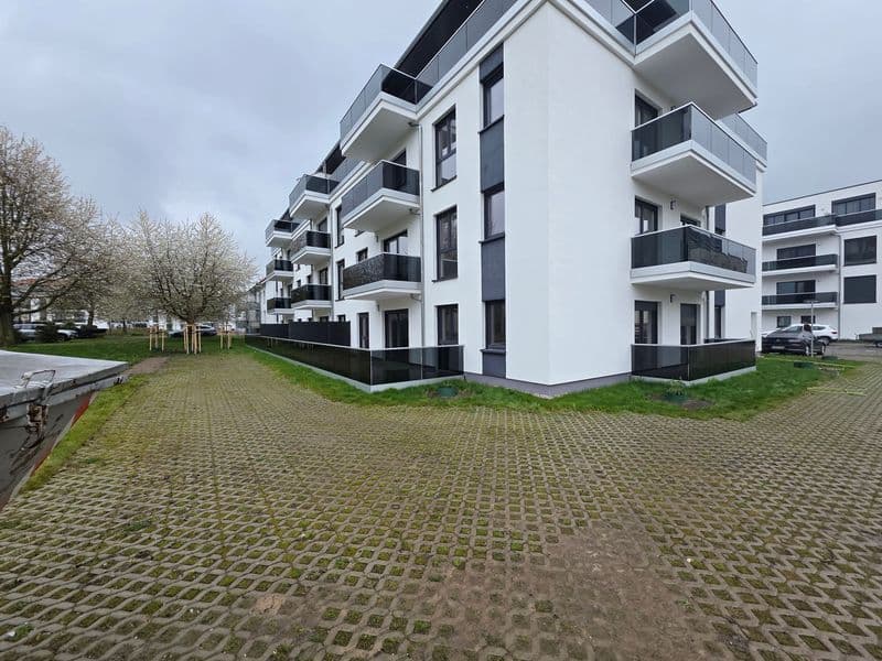 Mehrgeschossiges Wohngebäude mit weißer Fassade, schwarzen Balkonen und Fensterrahmen, Rotdornstraße in Leipzig-Paunsdorf