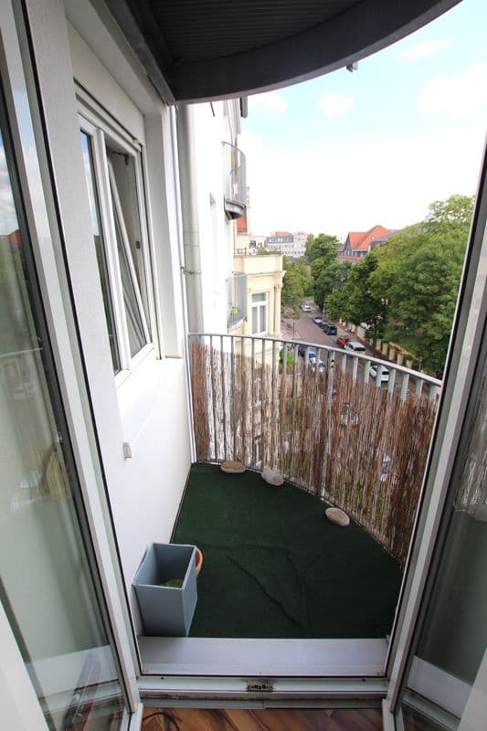 Balkon mit Kunstrasen, Holzgeländer und Blick auf Straße mit Bäumen, Salomonstraße in Leipzig