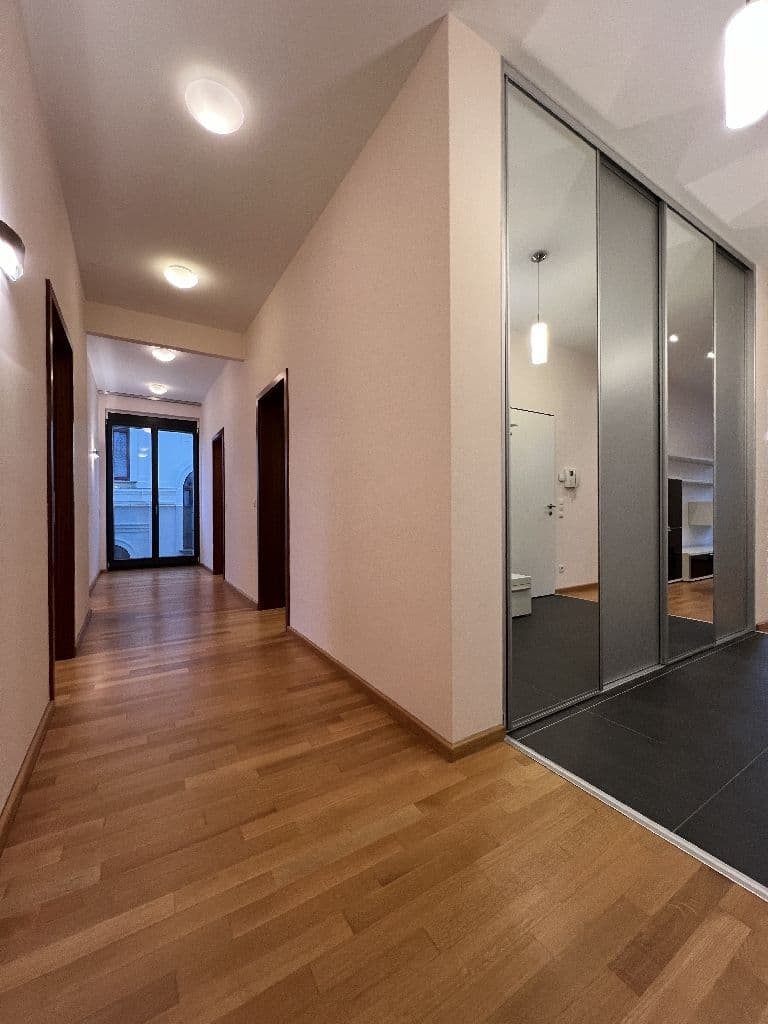 Flur mit Holzparkett, heller Decke mit Einbaustrahlern, beige Wände und Schiebetüren mit Spiegelfront