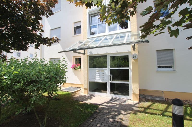 Hauseingang mit Glastür und Vordach, weiße Fassade, grüne Hecke, gepflasterter Hof, Seehausener Allee in Leipzig-Seehausen