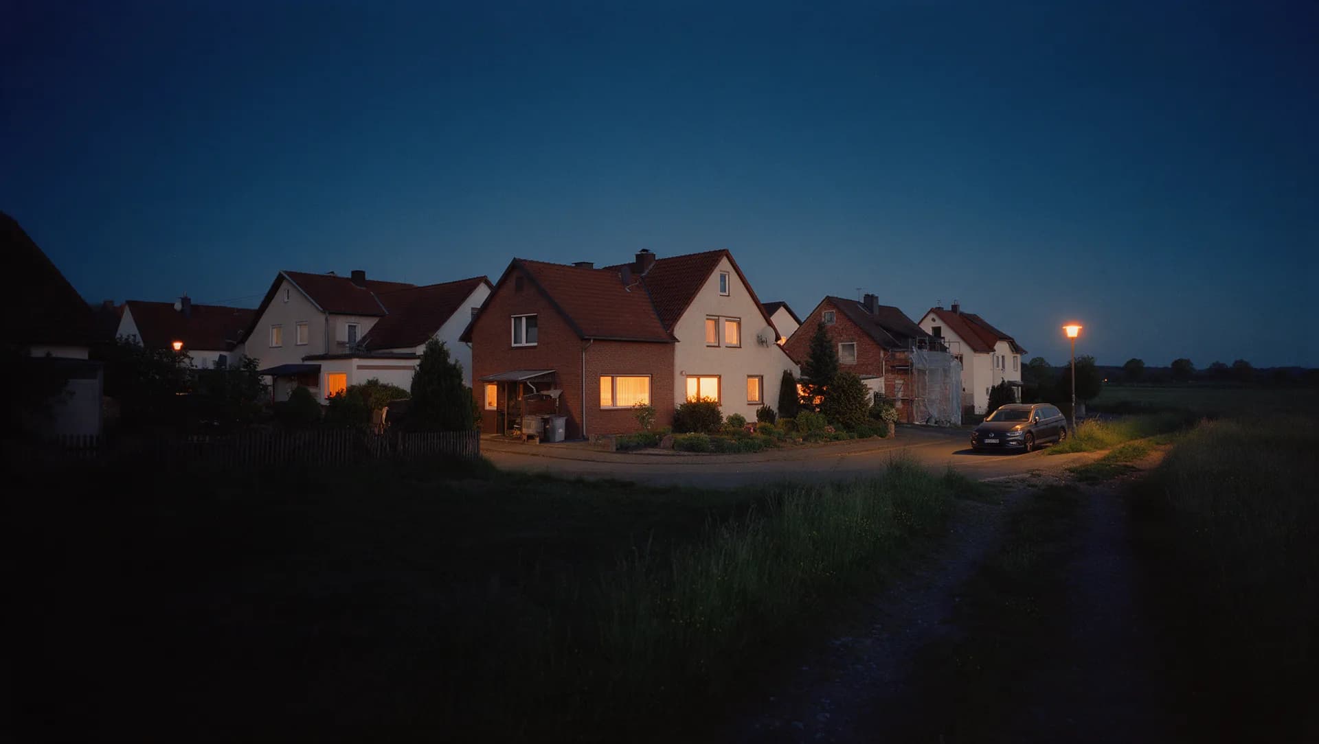 Ortsrand mit Einfamilienhäusern und angrenzender Wiese, wie am Rand von Lutherstadt Wittenberg