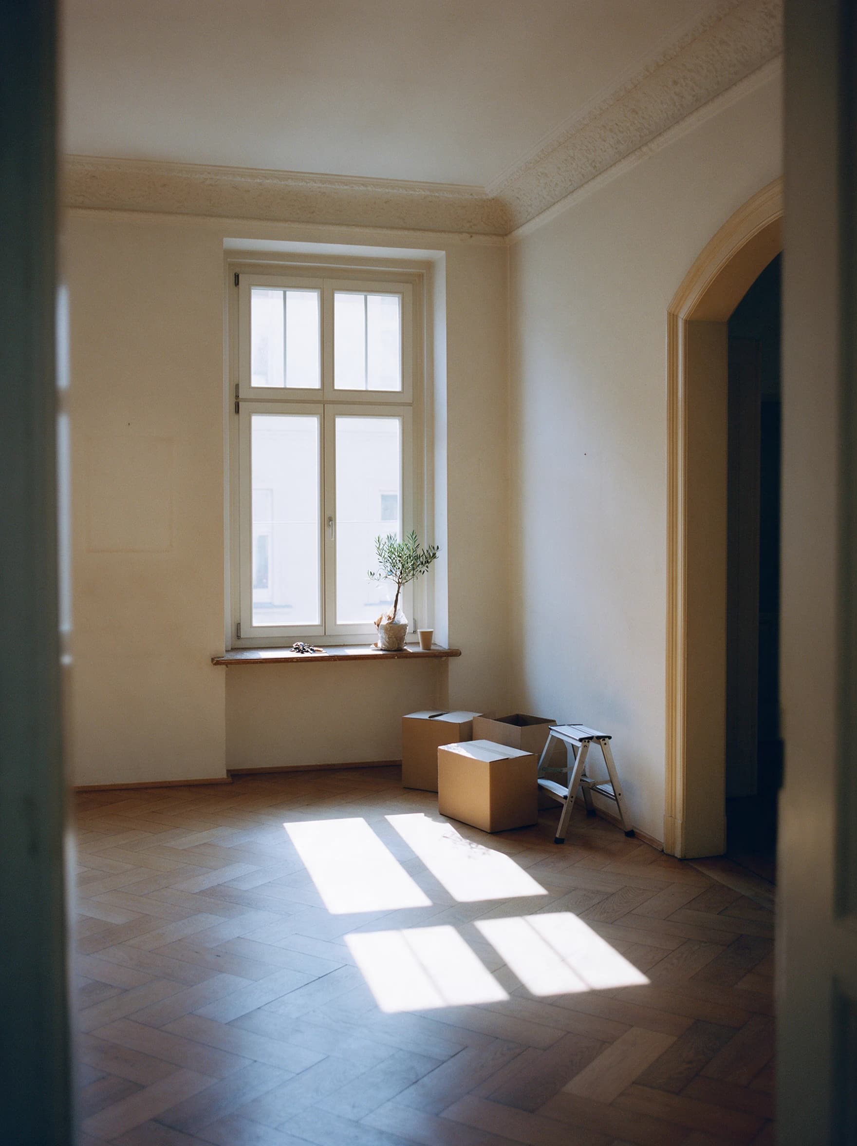 Gerade übergebene Altbauwohnung in Leipzig, Umzugskartons an der Wand, Schlüssel auf der Fensterbank