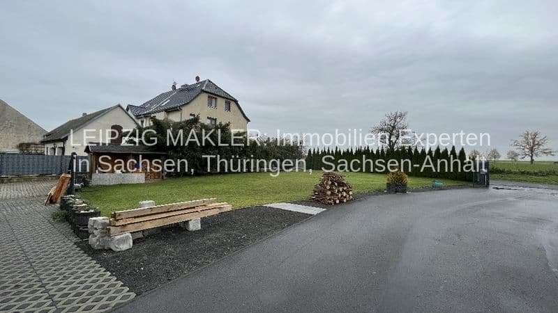 Zweistöckiges Wohnhaus mit Satteldach und Putzfassade, großes Grundstück mit Zufahrt und Grünfläche