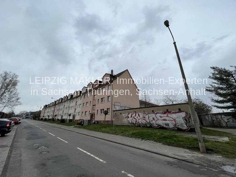 Mehrgeschossige Wohnzeile mit Mansarddach, Putzfassade, Straßenseite mit Parkplätzen, Mockau in Leipzig-Mockau-Süd