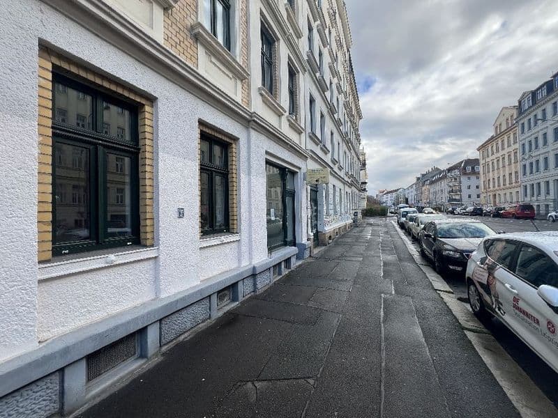 Mehrgeschossiges Gründerzeithaus mit weißer Fassade, grünen Fenstern und Ladenfront, Brandstraße in Leipzig-Connewitz