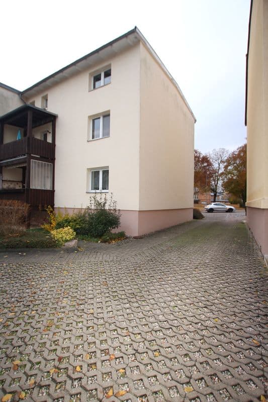 Dreigeschossiges Wohnhaus mit heller Fassade und rosafarbenem Sockel, Satteldach, Wiesenstraße in Delitzsch