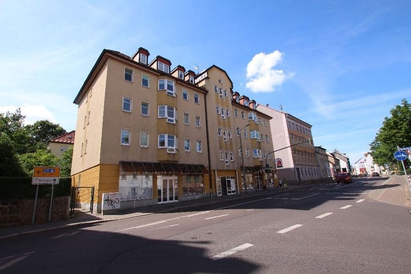 Fünfgeschossiges Wohngebäude mit beige-roter Fassade, Mansardendach und Ladengeschoß im Erdgeschoss, Dieskaustraße in Leipzig