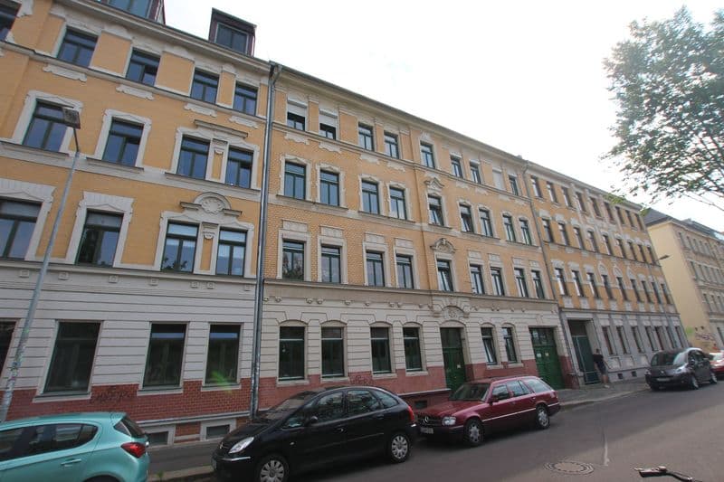 Fünfgeschossiges Gründerzeithaus mit ockergelber Fassade, Mansardendach und Rustika-Sockel, Industriestraße in Leipzig