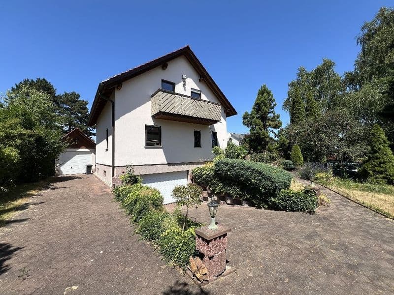 Einfamilienhaus mit weißer Fassade, dunklem Satteldach und Metalldachdeckung, Marcher Straße in Leipzig