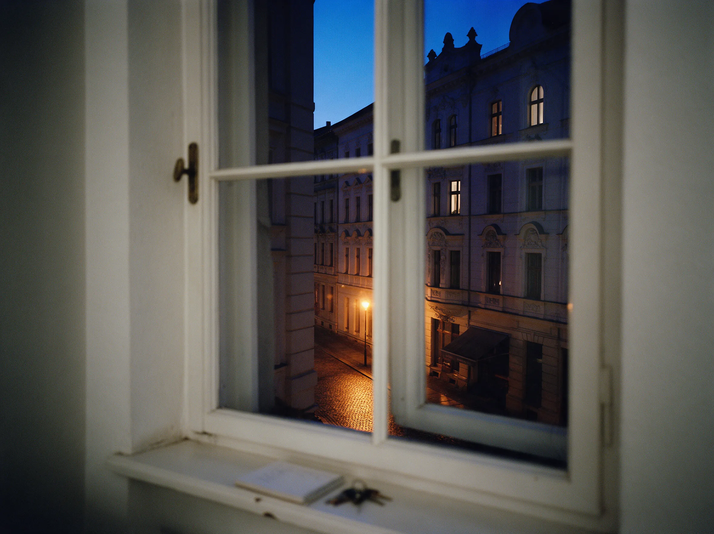 Blick aus einem Bürofenster auf eine Leipziger Gründerzeitfassade zur blauen Stunde